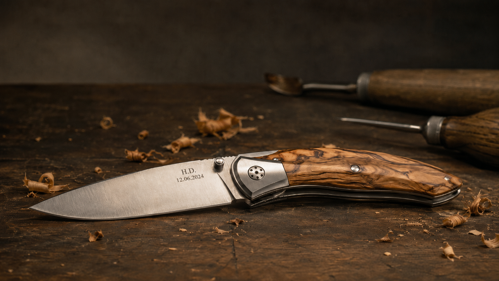 Couteau pliant artisanal personnalisé avec manche en bois d’olivier et gravure laser sur la lame.